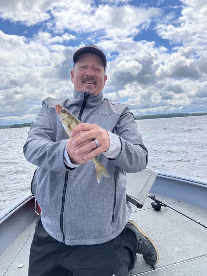 David Sheets holding a walleye on a lake